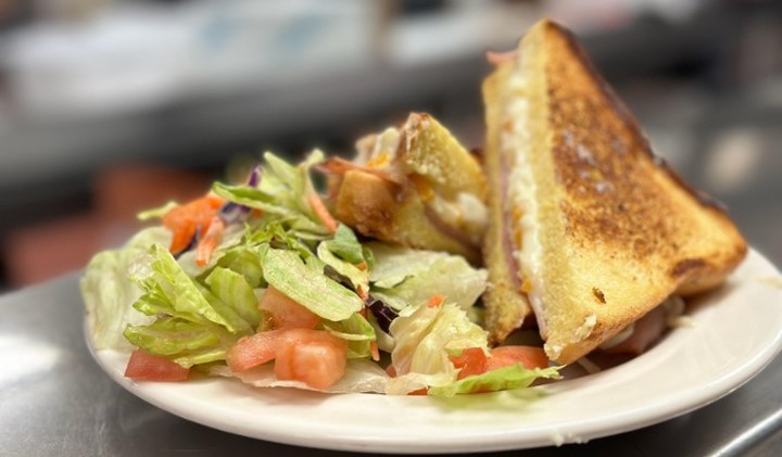 Clubhouse Sandwich with Vegetables in a white plate
