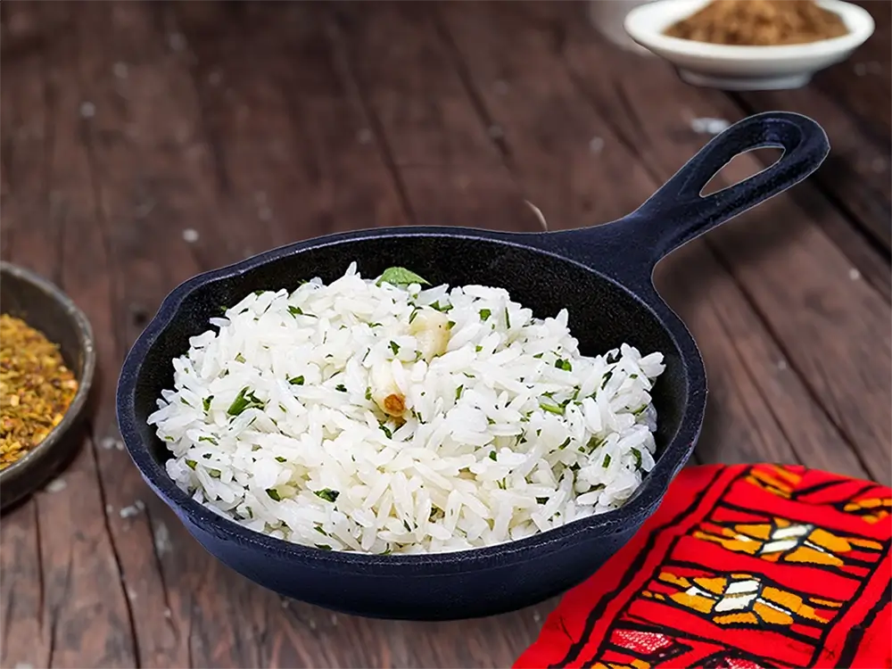 A black skillet filled with fragrant rice and colorful spices sits invitingly on a wooden table.